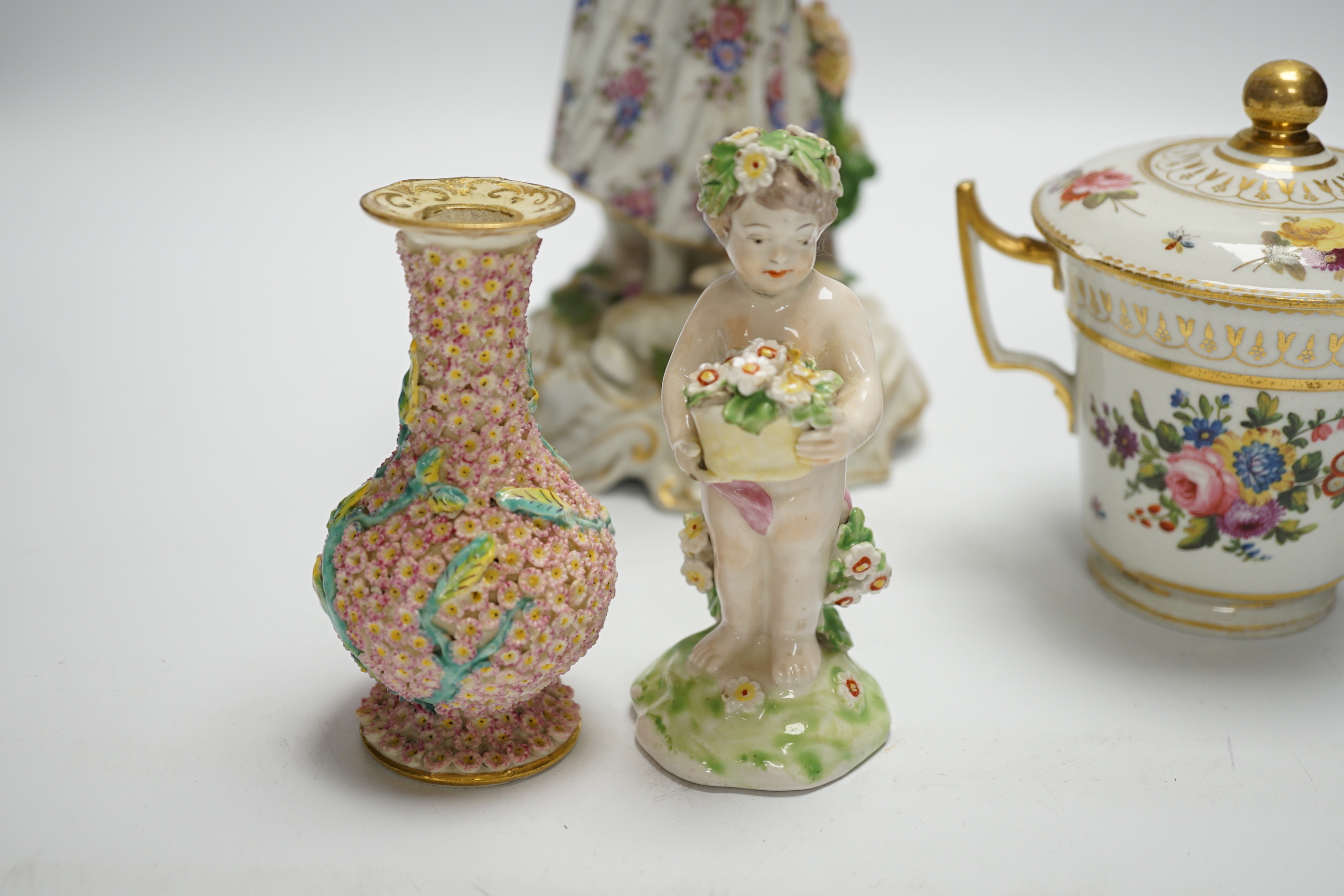 A late 19th century Continental porcelain figure of a lady, a Pinxton-type chocolate cup and cover, a Derby putti and a small Minton flower encrusted vase, figure 24.5cm (4)